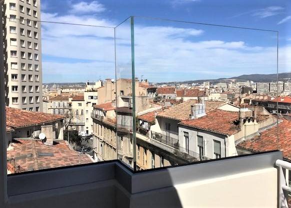 Fourniture et pose d'un brise vent en verre au style design et discret  pour un balcon à Marseille