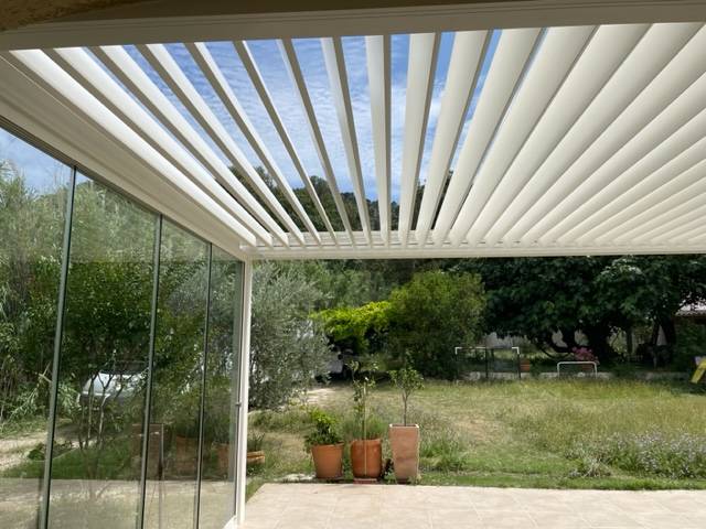 Pergola bioclimatique équipée d'un rideau de verre