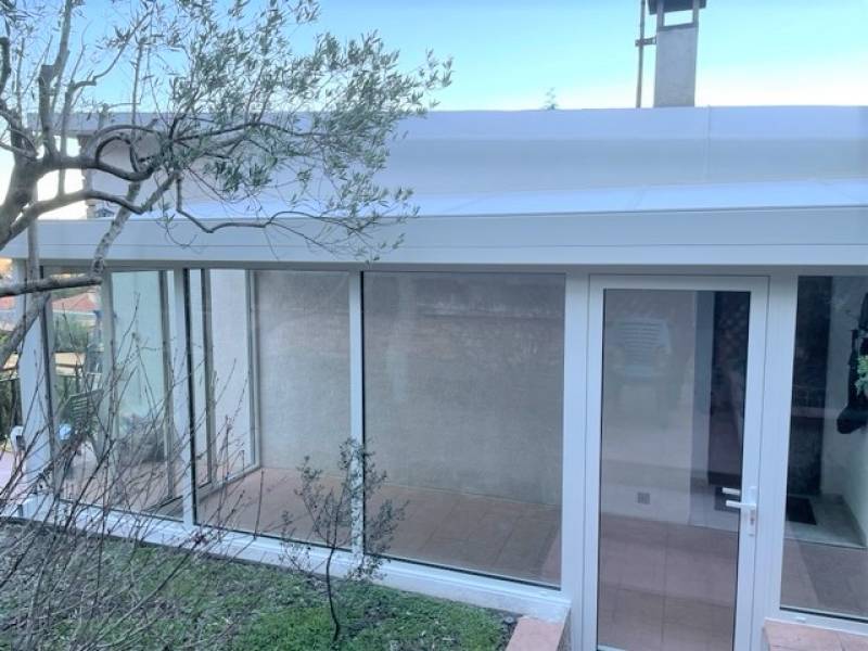 Face avant de la véranda aluminium avec châssis coulissant 3 vantaux et porte 1 vantail